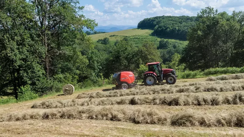 La presse à balles rondes à chambre fixe KUHN FB 3125 en train de presser des balles rondes d'ensilage.