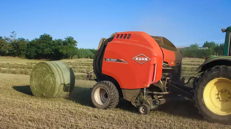 Presse à balle ronde à chambre variable KUHN VB 3285 en train de produire des balles de paille