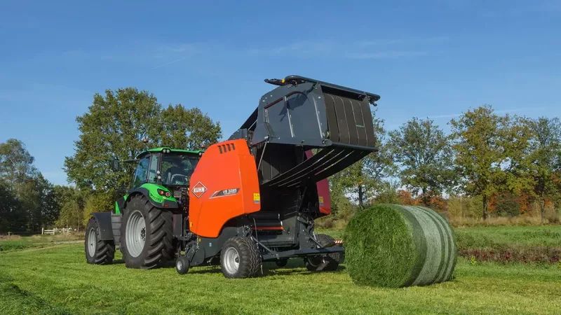 Presse à balle ronde à chambre variable KUHN VB 3260 en train de produire des balles de foin