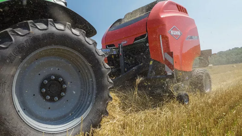 Presse à balle ronde à chambre variable KUHN VB 3260 en train de produire des balles d'enrubanné