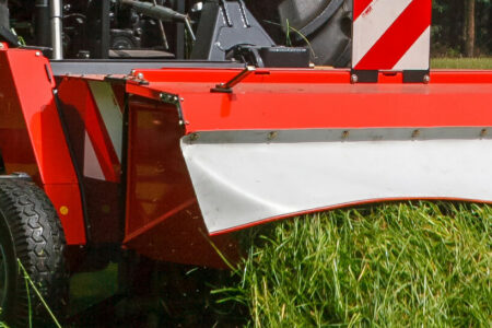 Mit der verstellbaren Abdeckhaube kann das Mähgut im Schwad abgelegt oder breit gestreut werden.