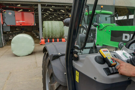 La version (C) pilotée par boîtier programmable avec télécommande à radio fréquence standard de la RW 1110 peut être commandée depuis un chargeur en utilisant une centrale hydraulique autonome ou un second tracteur pour alimenter l'enrubanneuse en huile et en électricité.