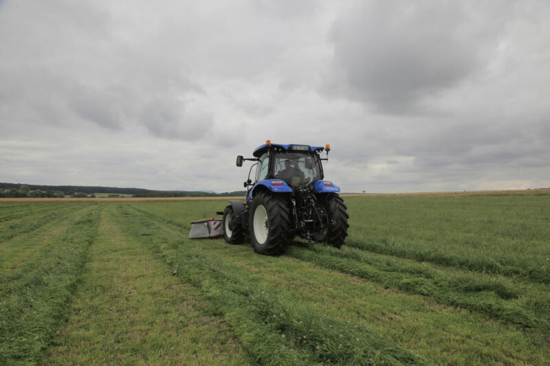 Photo d'un andain toujours parfaitement déposé entre les roues du tracteur