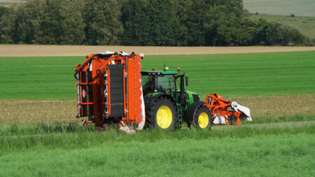 La faucheuse-conditionneuse à tapis regroupeur d'andains au transport sur route