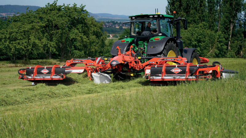 Photo de la faucheuse-conditionneuse à tapis regroupeurs d'andains FC 9330 RA au travail dans une prairie