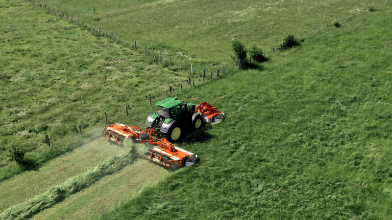 Photo de la faucheuse  triples à tapis FC 9330 RA KUHN au travail dans une prairie, en bordure de parcelle