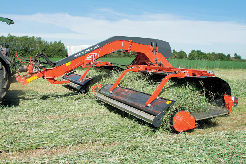 Photo de l'andaineur à tapis MERGE MAXX 950 au travail dans une prairie